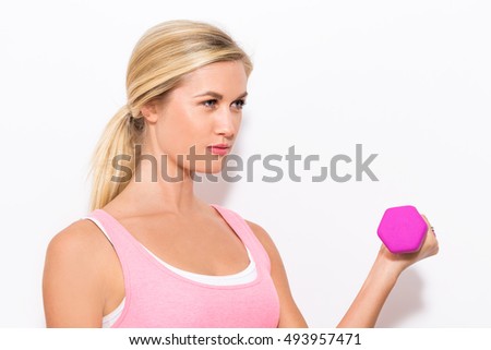Young blonde woman working out with a dumbbell