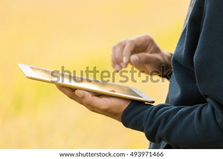Man using digital tablet PC in the park.
