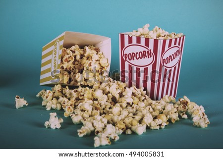 Bucket of popcorn against a blue background Vintage Retro Filter.