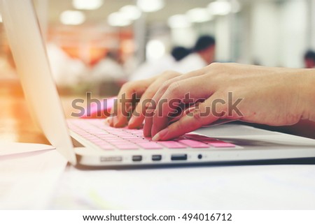 business, education, people and technology concept -  close up of female hands typing on keyboard of laptop computer with Blurred education people.