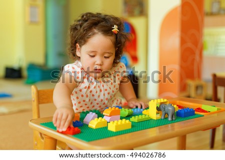 kazakh curly girl playing in kids development center