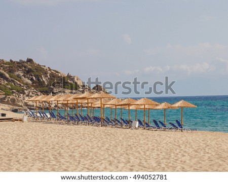 Sand Beach with sun umbrella and sunbeds. Summer vacation