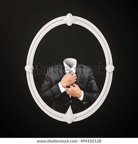 Invisible man in black suit, in white oval picture frame on black wall