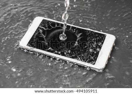 Motion movement of water poured over a smartphone / a wet smartphone concept