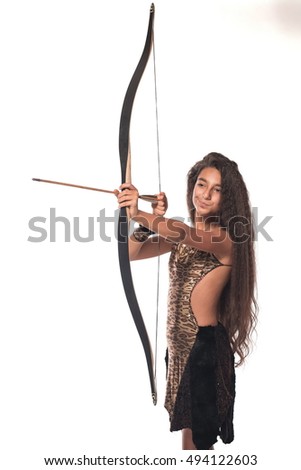 Emotional brunette girl with long hair in the Amazon costume with bow and arrow on a white background.