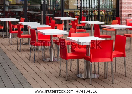 Beautiful view with tables and chairs at a open terrace cafe in mediterranean town  Square toned image, instagram effect
