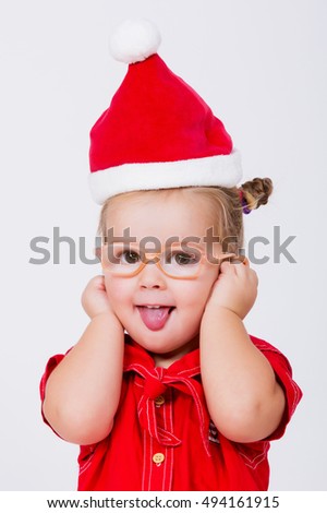 Baby in Christmas bonnet looks at camera, on white background.