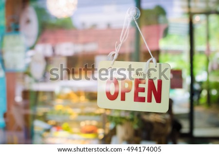 Open sign broad through the glass of door in cafe. Business and service concept. 