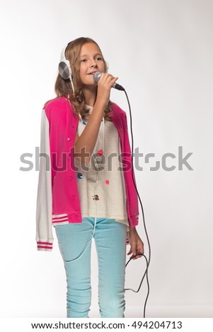 Emotional blonde girl in a pink jacket with a microphone and headphones.