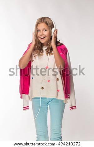 Emotional blonde girl in a pink jacket with headphones.