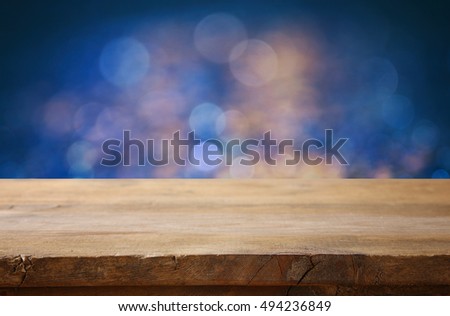 Empty table in front of blue glitter lights background. For product display montage