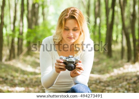 young woman taking photo in the forest