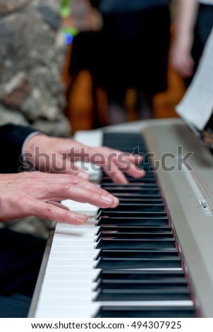 Male hands playing the piano, press the keys, music concept