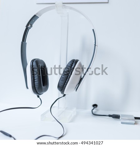 Headphone Black hung on the wall above the white table 