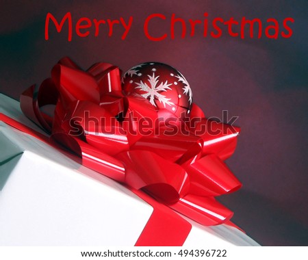 "Merry Christmas" in script with a wrapped holiday package and ornament in the picture.