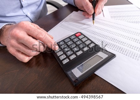 Man with calculator doing his accounting