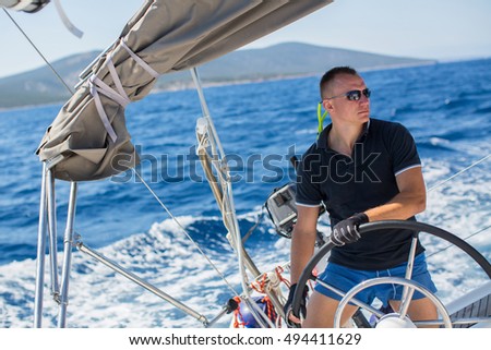Yachtsman during in the race, sailing the Aegean sea. Royalty-Free Stock Photo #494411629