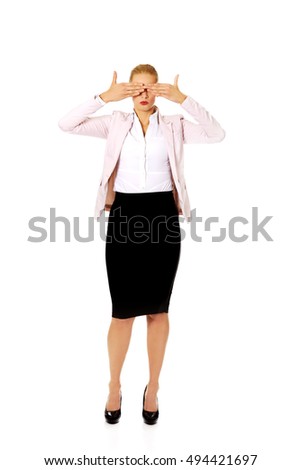 Business woman covering her eyes with her hands. See no evil concept