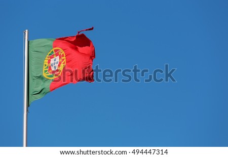 Portuguese flag waving over blue sky