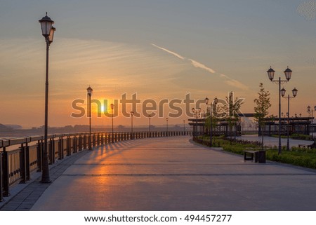 Kazan city, Tatarstan, Russia. Morning panoramic view of the embankment of the river Kazanka. The sun light reveals the silhouettes of the lanterns.