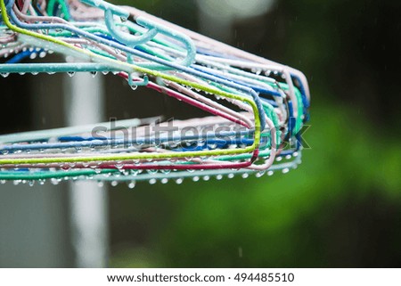 Picture hangers, wet rain in the morning on a clothes line in front of the house.