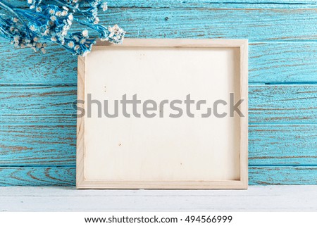 Wood frame and flowers with blue wooden wall