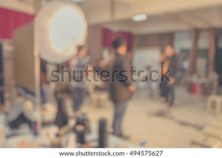 vintage tone blur image of photographer working in studio for background usage.