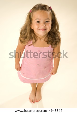 Contemporary portrait of a beautiful little girl. She looks very happy and has smiling eyes that look directly to the viewer. High angle and wide angle lens give an interesting perspective.