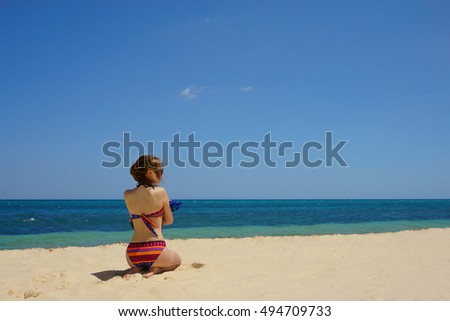 girl in bikini on the beach by the sea