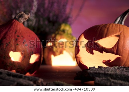 Halloween pumpkin head jack lantern with scary evil faces spooky holiday with burning candles over wooden background. Halloween holidays art design, celebration. Place for typography and logo.