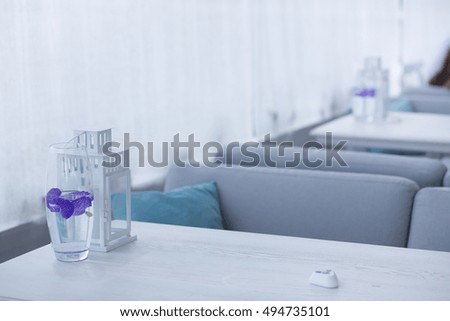 restaurant table decoration with orchids in a vase and candle holder