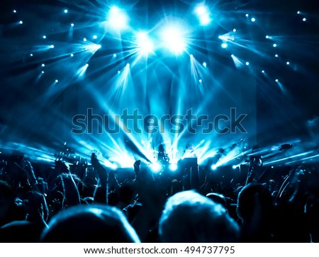 silhouettes of concert crowd in front of bright stage lights Royalty-Free Stock Photo #494737795