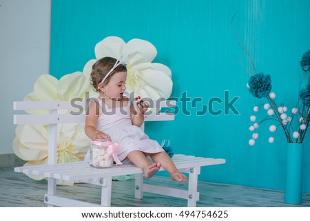 Little charming girl on a bench with a cake