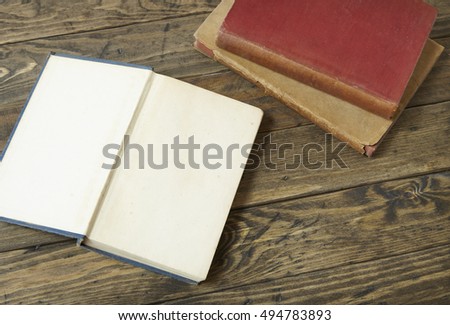 An open blank book on an old wooden desk top background 