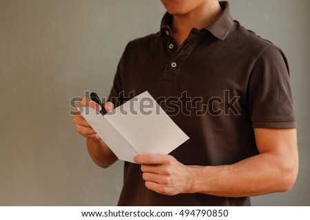 Man makes notes in blank white flyer brochure booklet. Leaflet presentation. Pamphlet hold hands. Man show clear offset paper. Sheet template.