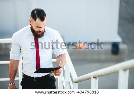 businessman stands with documents in hand in the street