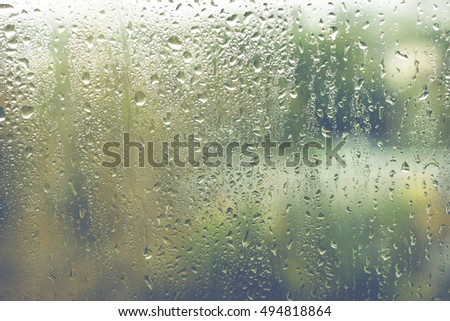 Rainy day. Water drops on window glass. Royalty-Free Stock Photo #494818864