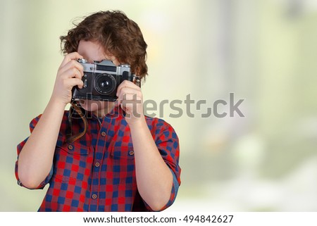 Cheerful smiling child (boy) holding a instant camera