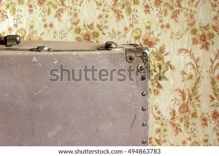 Vintage classic american shabby locked suitcase close up, retro background, old wallpaper