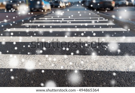safety, traffic laws, highway code and road sign concept - close up of pedestrian crosswalk on city car parking over snow