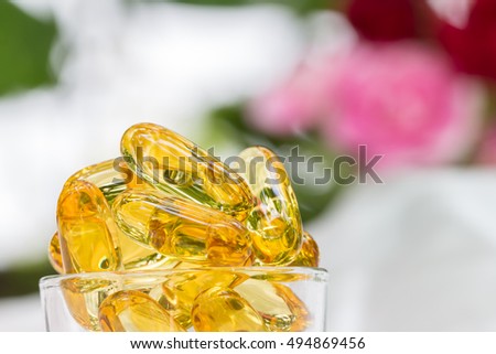 Macro image, pile of fish oil capsules on a white and pink background.