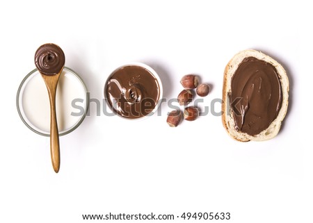 chocolate and hazelnut spread with milk and hazelnuts over white background. top view Royalty-Free Stock Photo #494905633