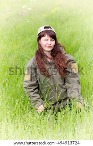 scout girl in military jacket. in emotions from green nature