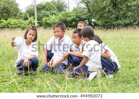 Portrait group of childrens taking a selfie with telephone in the field