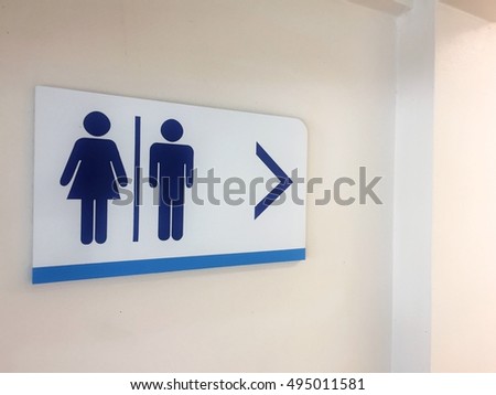 Signs to the toilet with a dim light.