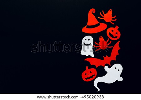Happy Halloween background with a border of ghost, pumpkins, bat, spider and witch hat cut out of paper. Happy Halloween card. Black background.