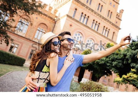 Happy couple of tourists taking selfie in old city