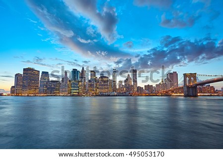The Manhattan skyline and Brooklyn Bridge as seen from across the East River at dusk. New York City at night