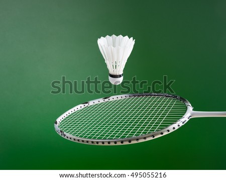 badminton ball and racket on green background