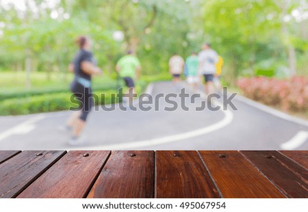 Look out from the table, blur image of people exercise in the park as background.